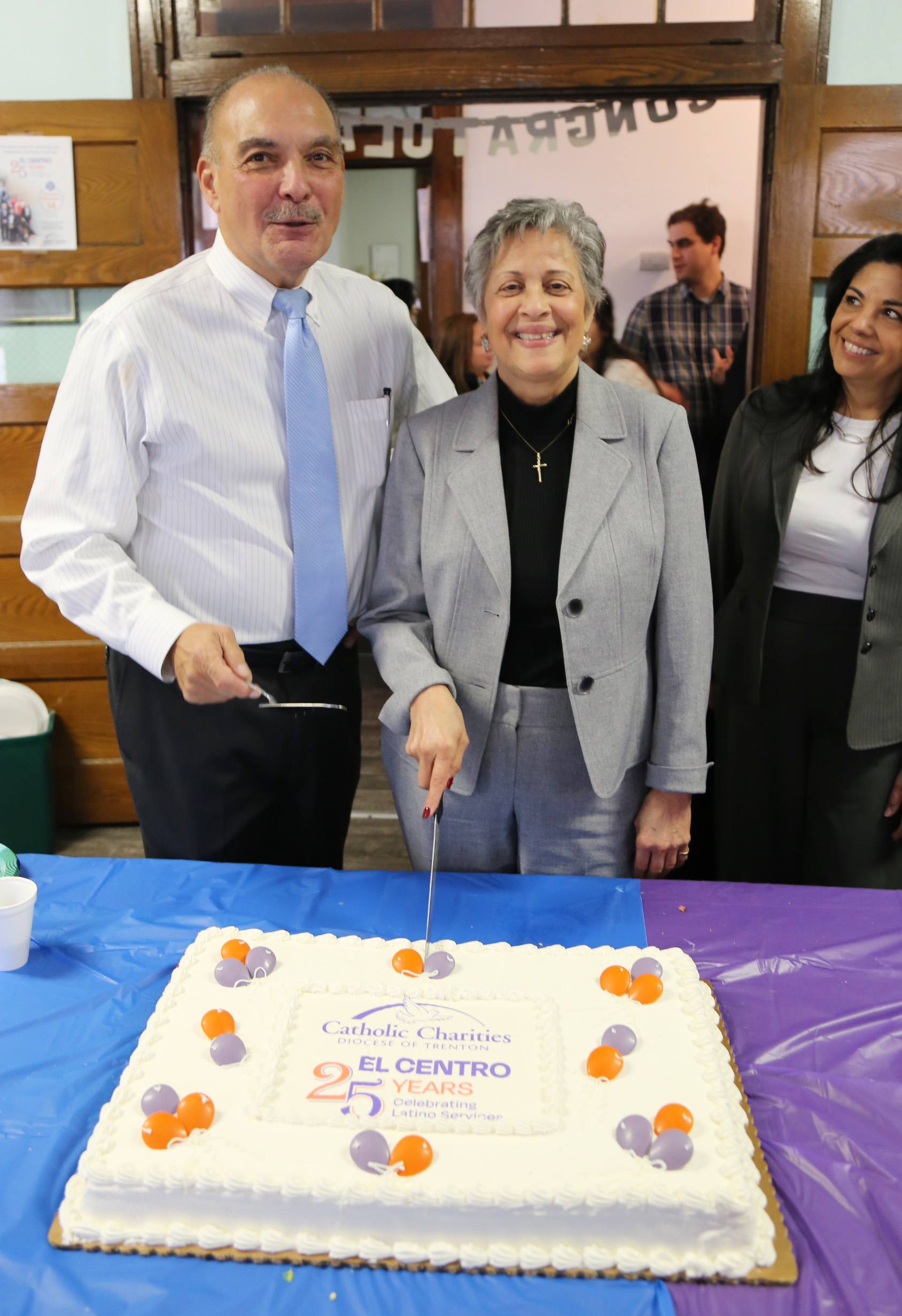 Roberto Hernandez and Marlen Lao Collins prepare to cut the cake decorated with Happy 25th Anniversary El Centro. 