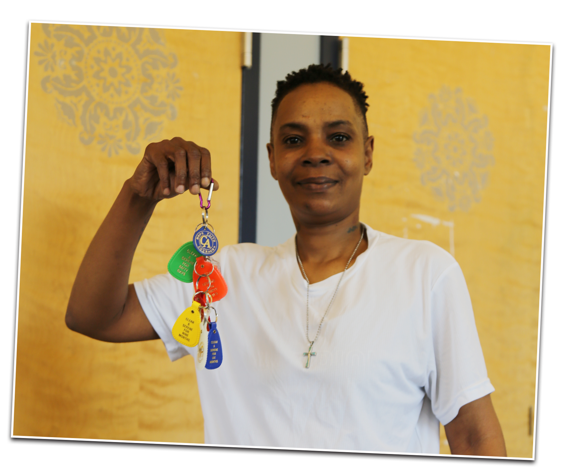 A young black woman holding a colorful bunch of keychains all clipped together. 